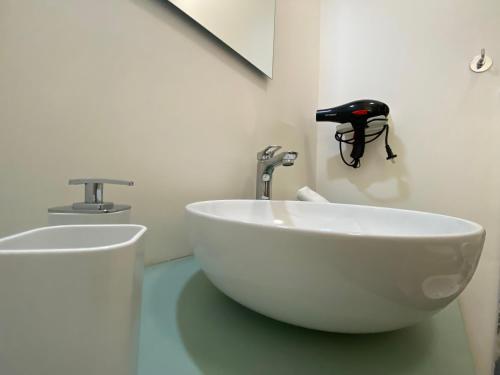 a bathroom with a white sink and a faucet at Le casette di Frà Host and Go in Santa Severa