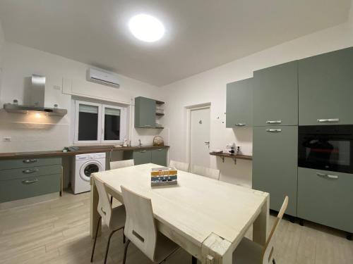 a kitchen with a table and chairs in it at Le casette di Frà Host and Go in Santa Severa