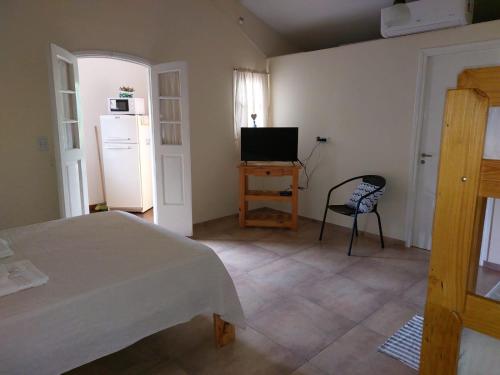 1 dormitorio con 1 cama, TV y silla en La Soñada II en Alta Gracia