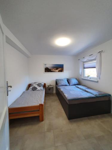 a bedroom with two beds and a window at Willa Wiselka in Wisełka