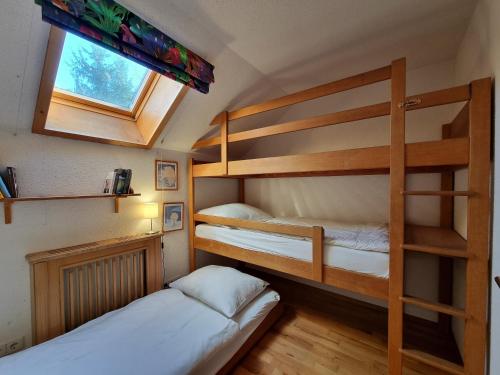 two bunk beds in a small room with a window at Blockhütte im Waldviertel in Brettl