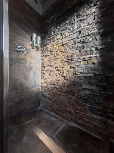 a bathroom with a brick wall and a shower at La casetta del Tuscolo -Secret rooms- in Grottaferrata