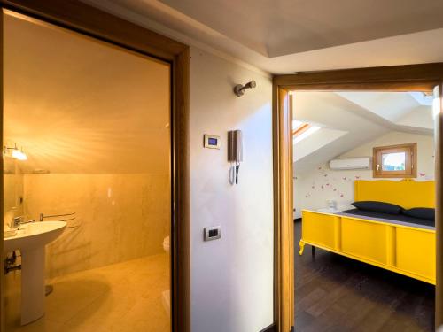 a bathroom with a yellow bed and a sink at La casetta del Tuscolo -Secret rooms- in Grottaferrata