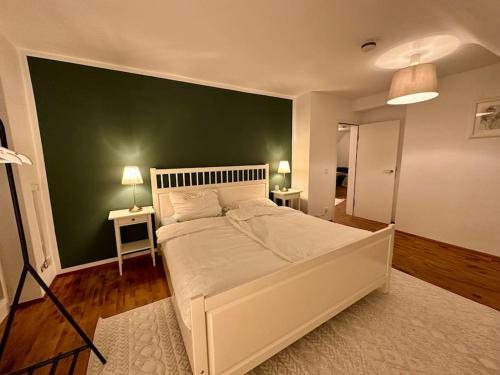 1 dormitorio con 1 cama blanca grande y pared verde en 77m² - 3 Zi Modern Zentrum Küche Dachterrasse WLAN, en Karlsruhe