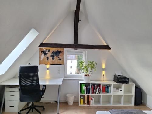 un bureau mansardé avec un bureau et une chaise dans l'établissement Ferienwohnung im Springerhof, à Lohr