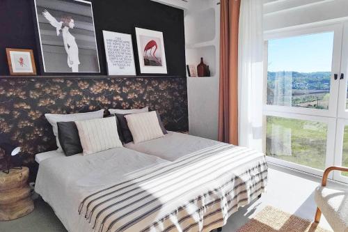 une chambre avec un grand lit avec une fenêtre dans l'établissement Domaine Lapèze, Gite Le Cabernet., à Montcuq