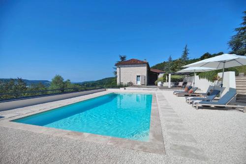 une piscine avec deux chaises et un parasol dans l'établissement Domaine Lapèze, Gite Le Cabernet., à Montcuq
