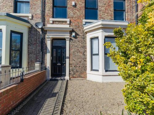 a brick building with a black door and windows at Longsands Beach, Apartment 4, Tynemouth in Tynemouth
