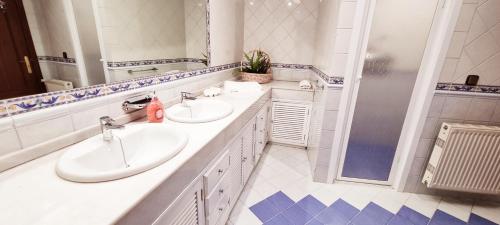 a bathroom with two sinks and a shower at Vivienda con fines turísticos "Casa Paquita" in Andújar