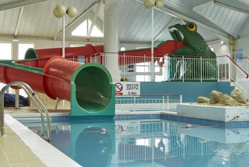 a swimming pool with a slide and a bird statue at 51 oaklands in Cowes