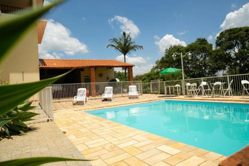 - une piscine avec des chaises et une clôture dans l'établissement Casa em Águas de Lindóia, à Águas de Lindóia