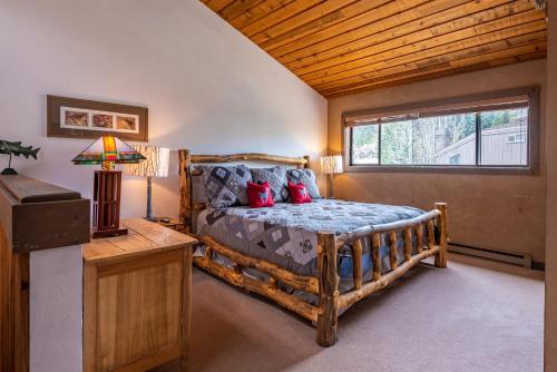 a bedroom with a wooden bed and a window at Bridgepoint Condo 24 - On Trail Creek & Walk to Downtown and Bald Mt in Ketchum