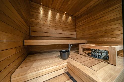 a small wooden sauna with a bucket in it at Slopeside Bliss C21 Levi Center by Aavalevi in Levi