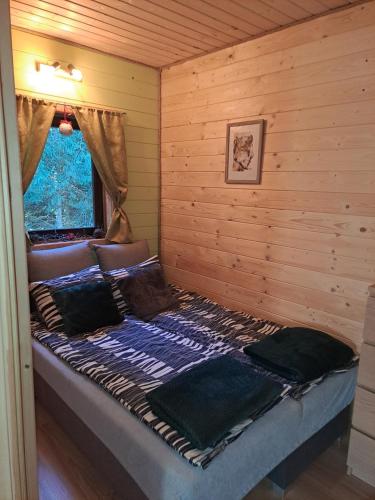 a bedroom with a bed in a log cabin at Chatki Małgorzatki in Bystre