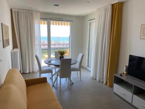 a living room with a table and chairs and a television at Nuovo Residence Serenissima Frontemare - Agenzia Cocal in Caorle
