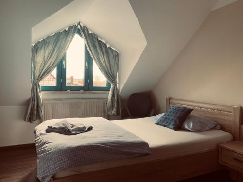 a bed in a room with a large window at Ryck-Hotel Garni in Greifswald