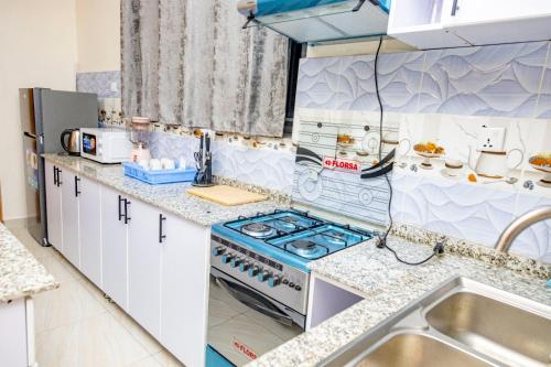 a kitchen with a stove and a sink at KIGALI GREET HOTEL in Kigali