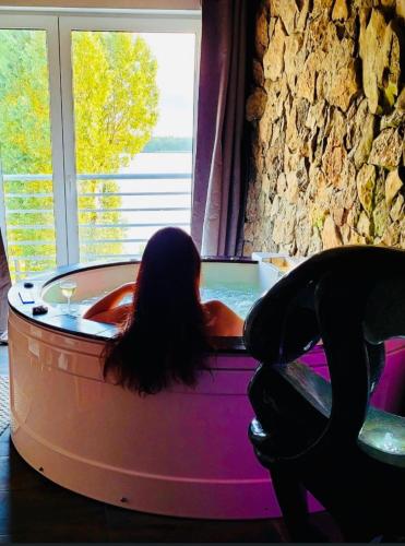 a woman laying in a hot tub in a room at EGZOTYCZNO - ROMANTYCZNE miejsce dla DWOJGA in Ełk