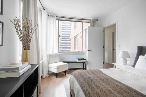 ein Schlafzimmer mit einem Bett, einem Stuhl und einem Fenster in der Unterkunft Central New York residence in New York