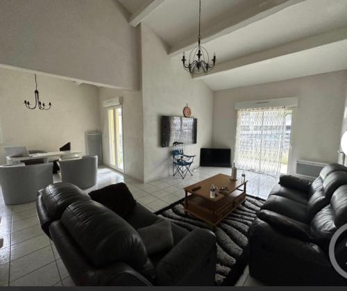 un salon avec un canapé et une table dans l'établissement Maison entière avec terrasse barbecue et jardin, à Nîmes