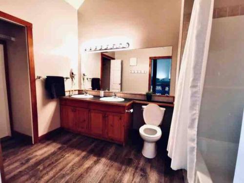 een badkamer met een toilet en een grote spiegel bij Cozy updated 3 BDRM/3 BTH on ski hill with private hottub (110) in Kimberley