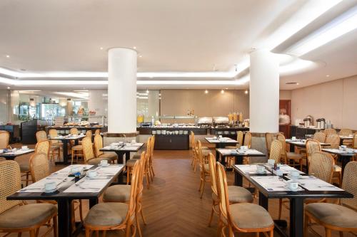 uma sala de jantar com mesas e cadeiras e uma cafetaria em Windsor Excelsior Copacabana no Rio de Janeiro