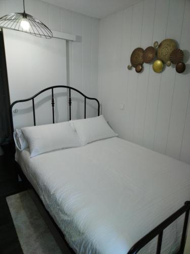 a bedroom with a white bed with a black headboard at Studio, La terrasse d'Isa in Dole