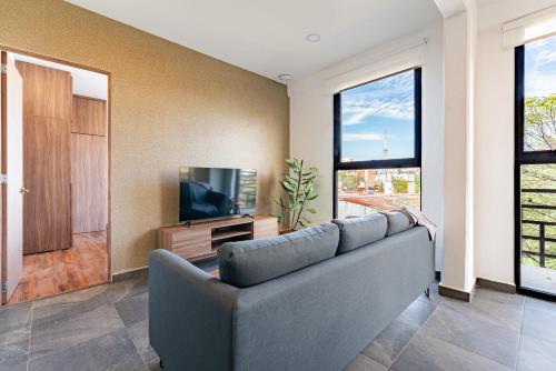 a living room with a couch and a television at Doctores Apartments by VH in Mexico City