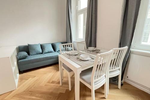 ein Wohnzimmer mit einem Tisch und einem Sofa in der Unterkunft Little Schönnbrunn1 Top Location in Wien