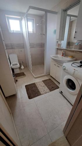 a bathroom with a shower and a washing machine at Konak in Novi Pazar