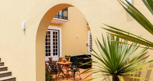 eine Terrasse mit Stühlen, einem Tisch und einer Pflanze in der Unterkunft Quinta da Nasce Água in Angra do Heroísmo