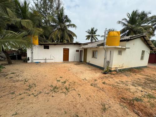 a white house with palm trees in front of it at Seaview Homestay Padubidri in Padubidri