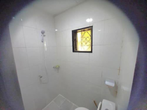 La salle de bains blanche est pourvue d'une douche et d'une fenêtre. dans l'établissement Impeccable 1-Bed Apartment, 