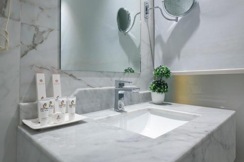 a white bathroom with a sink and a mirror at Holiday Plus Al Salamh- هوليداي بلس السلامه in Jeddah