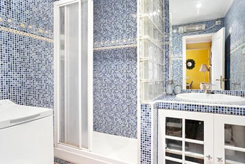 uma casa de banho em azulejos azuis com um lavatório e um espelho em Cosy, seaview apartment, close to beach and bars -Edificio RHIN em Campoamor