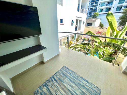 a balcony with a flat screen tv and a rug at Charme 64 Hotel Boutique in Cartagena de Indias