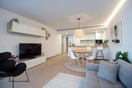 a living room with a couch and a table and a kitchen at Sea View Apartment Near The Beach in Fuengirola