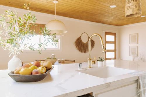 a kitchen with a bowl of fruit on a counter at Remote Home Shroom Room Hot Tub Pool Sauna in Sunfair Heights