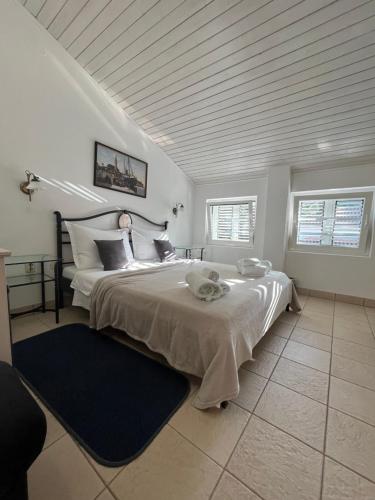 1 dormitorio con 1 cama grande y 2 ventanas en B&B Baron Gautsch en Rovinj