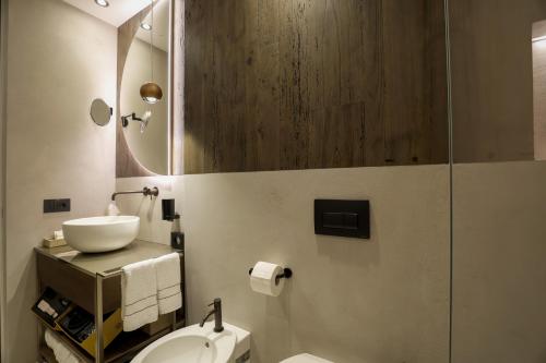 a bathroom with a sink and a toilet and a mirror at Collina Luxury Relais in Clusone