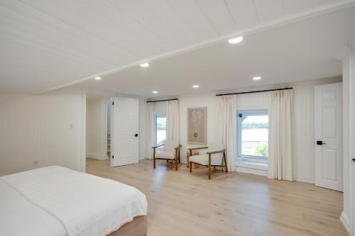 a white bedroom with a bed and a desk at Muskoka Rise in Rosseau