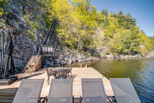 a dock with a table and chairs on the water at Muskoka Rise in Rosseau