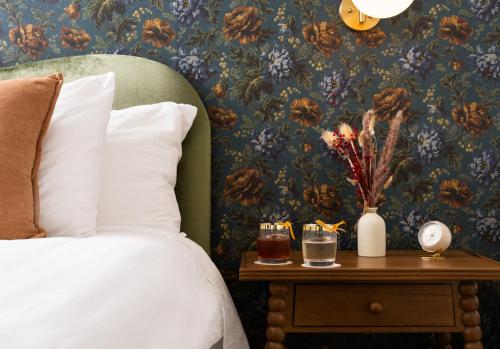 a bedroom with a bed and a table with a nightstand with a side table at Petit Soleil - Bed, Breakfast and Bar in San Luis Obispo