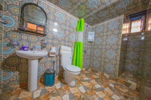 La salle de bains est pourvue de toilettes, d'un lavabo et d'un miroir. dans l'établissement Maison Adam, à Fès