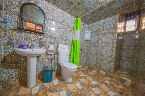 a bathroom with a toilet and a sink and a mirror at Maison Adam in Fès