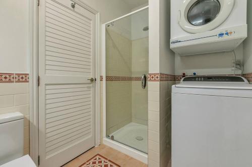 a bathroom with a shower and a washing machine at AWSA Stunning Sea View - 4005 in Auckland