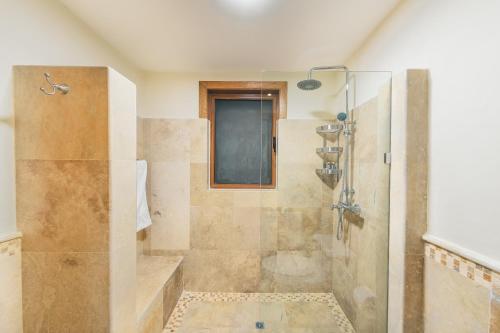 La salle de bains est pourvue d'une douche avec une porte en verre. dans l'établissement Luxurious Villa at Puerto Bahia with Great Views, à Santa Bárbara de Samaná