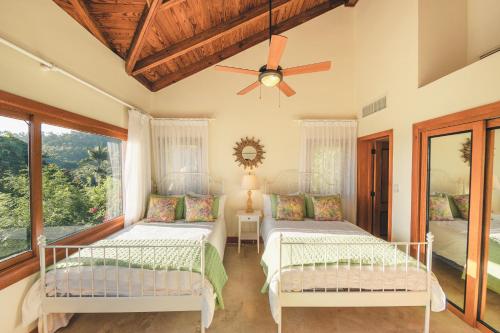 - une chambre avec 2 lits et un ventilateur de plafond dans l'établissement Luxurious Villa at Puerto Bahia with Great Views, à Santa Bárbara de Samaná