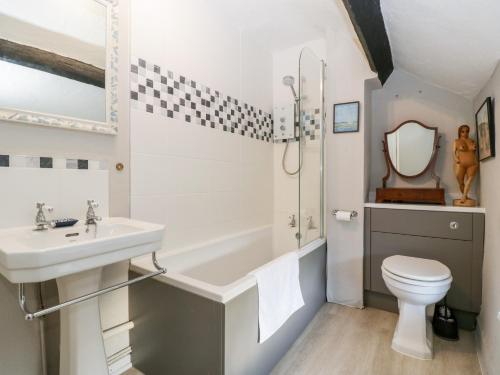 ein Badezimmer mit Waschbecken, Badewanne und Toilette in der Unterkunft Yew Tree Cottage in Leominster