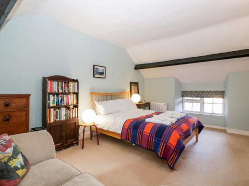 a bedroom with a bed and a book shelf at Yew Tree Cottage in Leominster